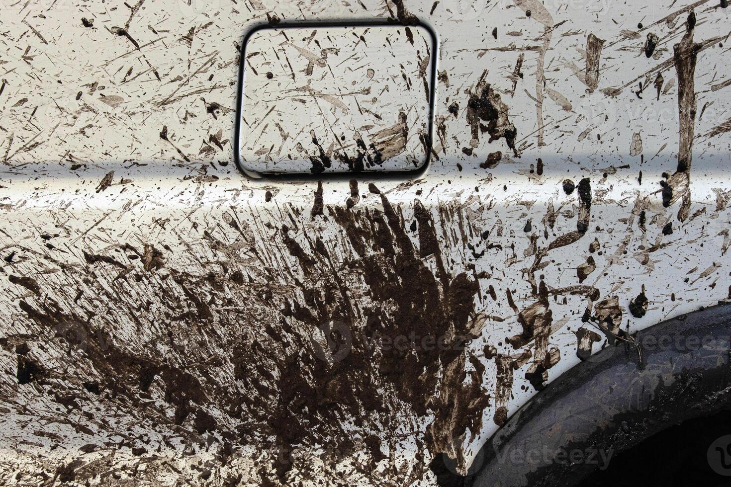 Dirty vehicle filler flap cap covered with mud splatters, wheels and tires. Closeup of a muddy car door covered in dirt. Importance of car wash, refueling, and safe driving concept 1 photo