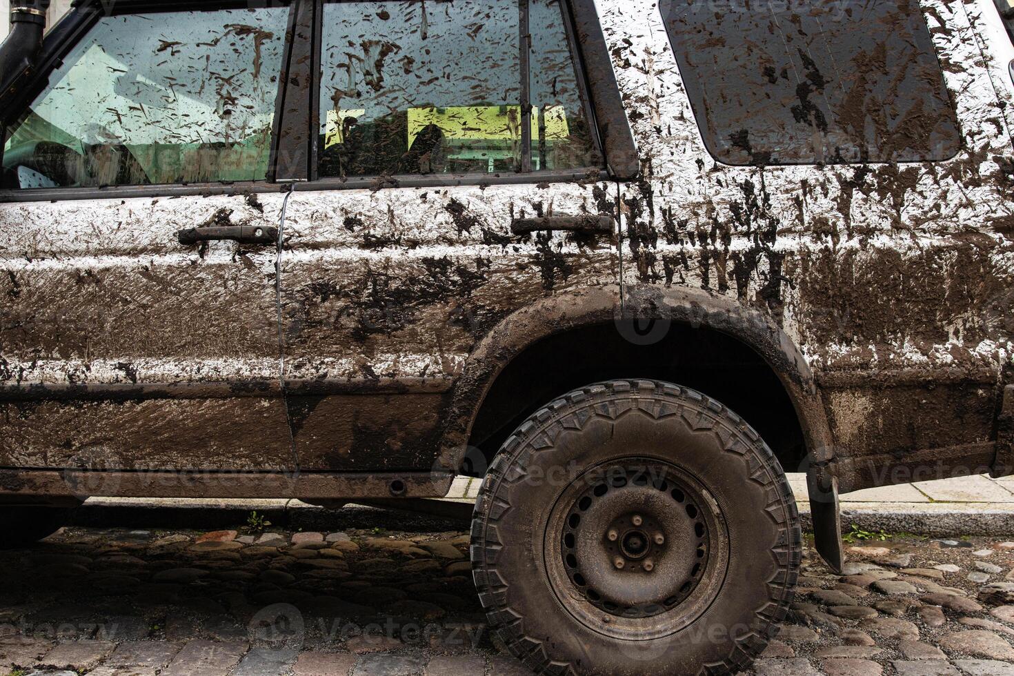 Dirty 4x4 vehicle with mud splatters on body, windows, wheels, tires. Dirty offroad suv car covered in dirt. Rugged terrain adventure, extreme driving, four wheel drive challenges 4 photo