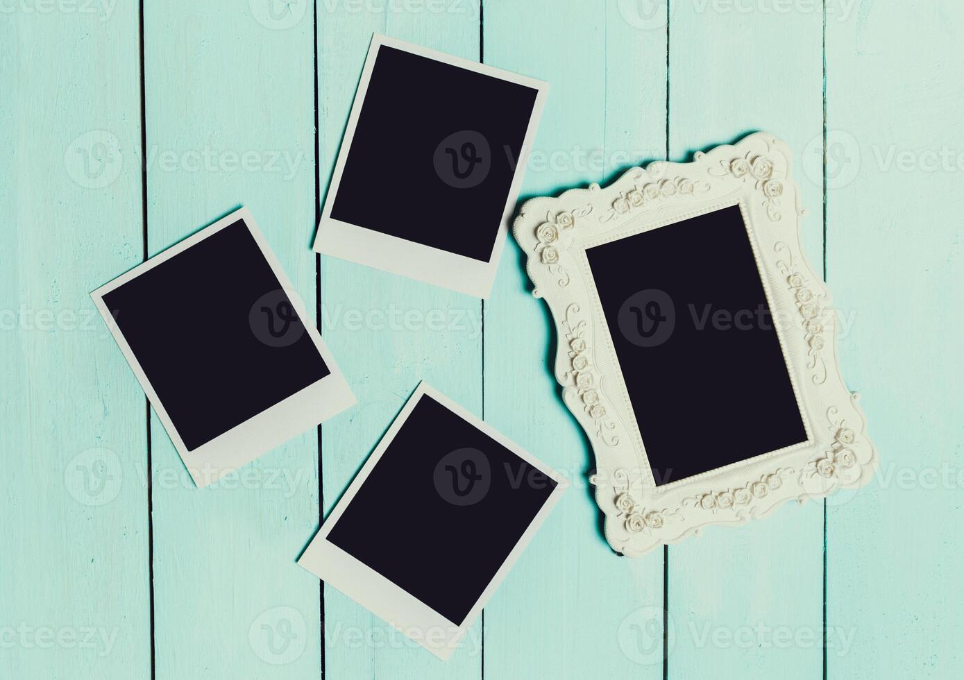 Collection of empty picture frames and polaroids on a light blue wooden background in a creative workspace photo