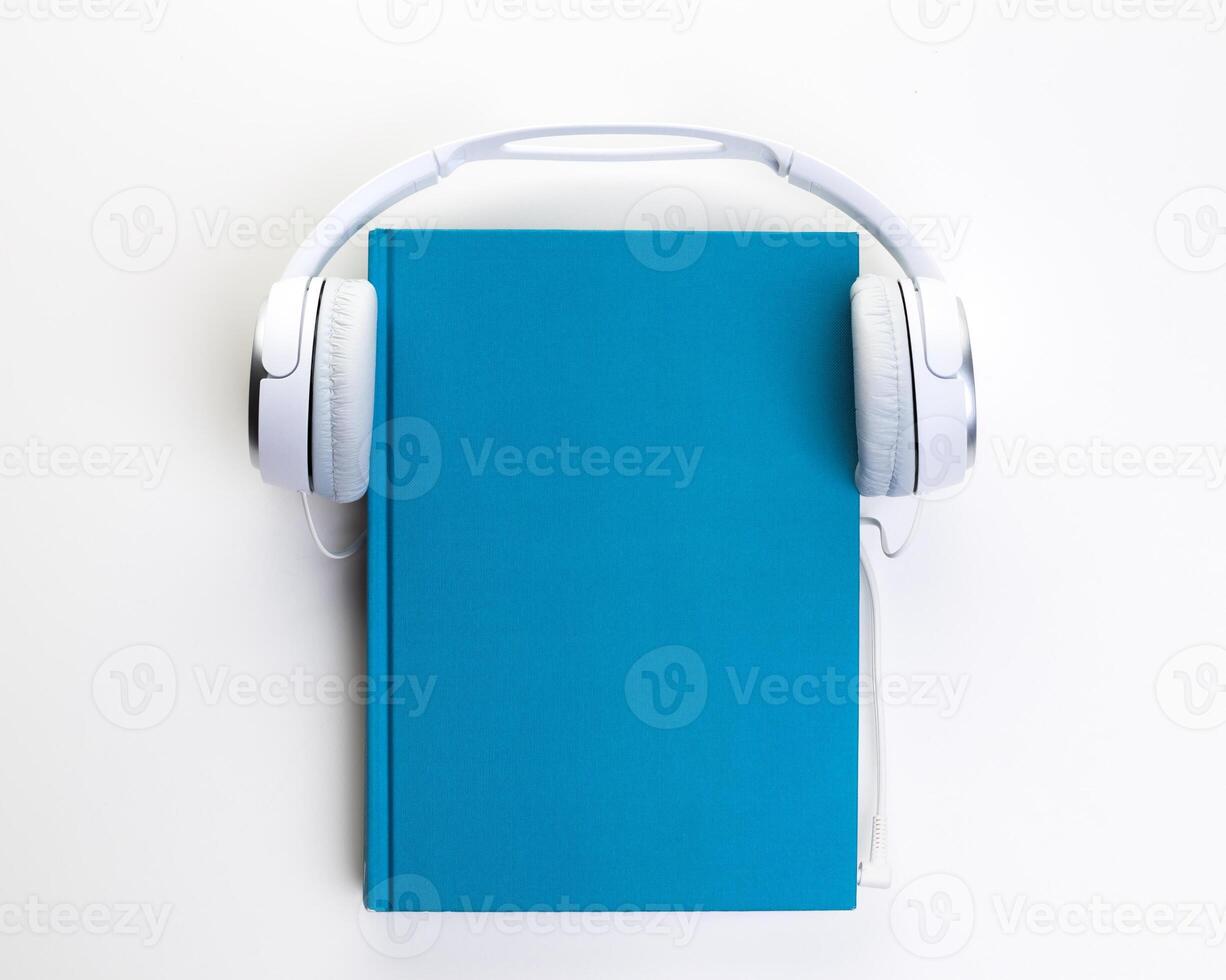 White headphones and notepad on white background photo