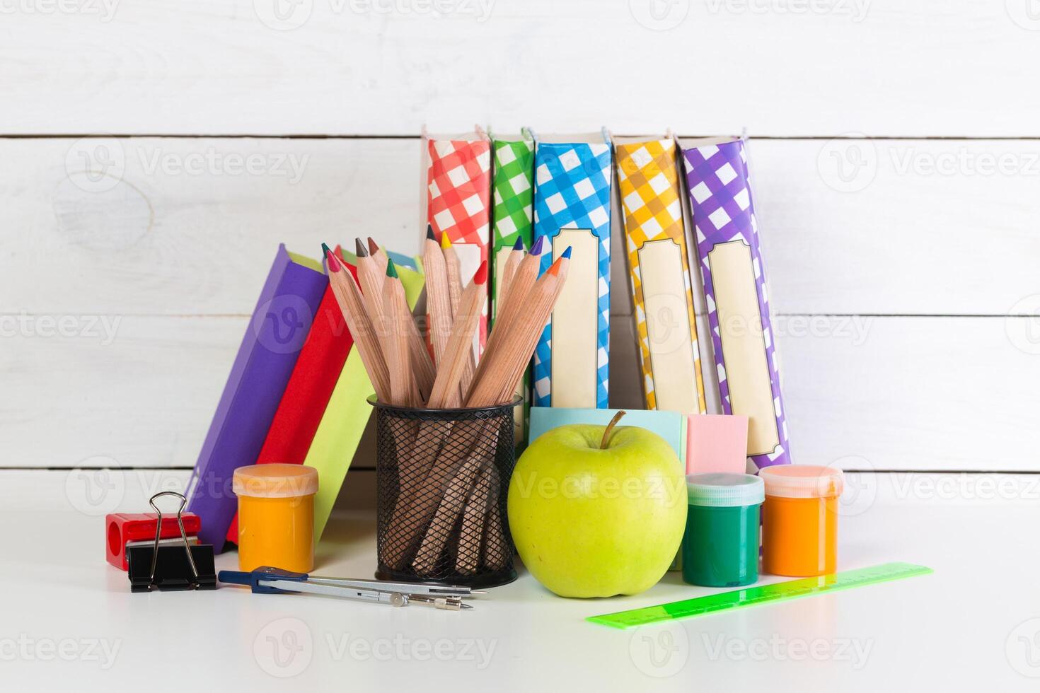 Set of school supplies on white table, front view photo