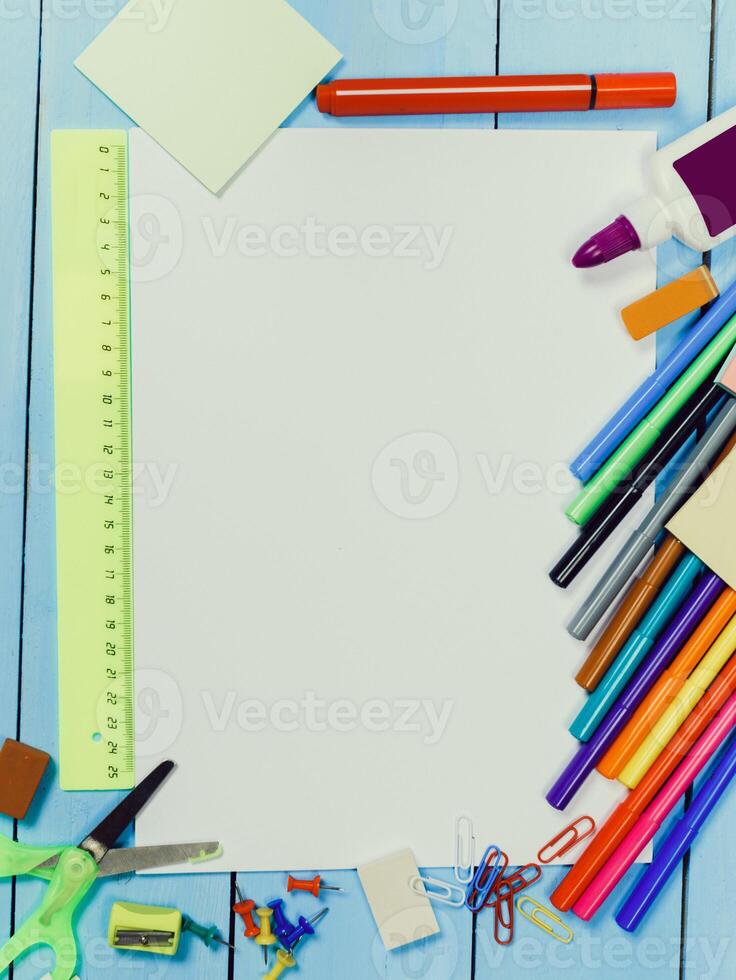 Creative workspace filled with colorful art supplies and blank paper on a blue wooden table photo