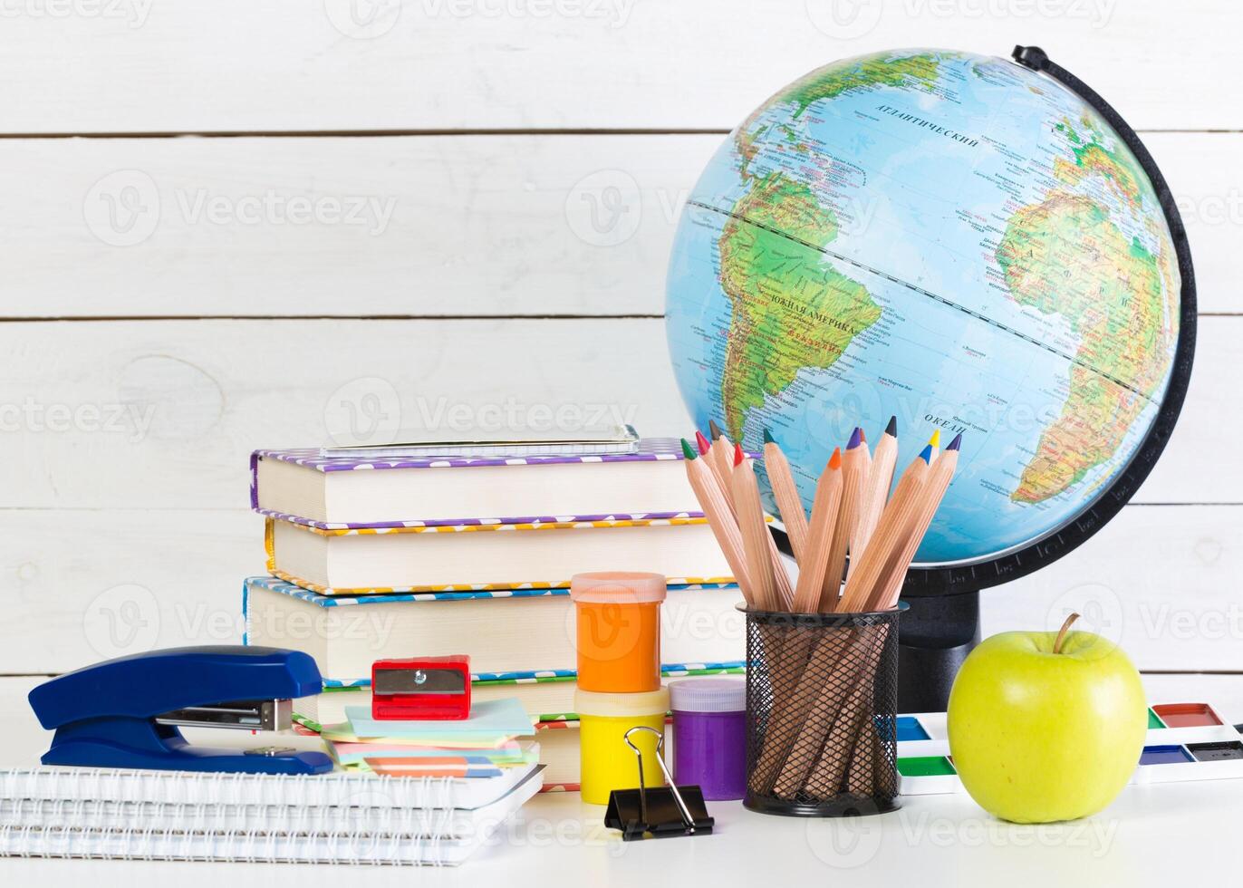Set of school supplies on white table, front view photo
