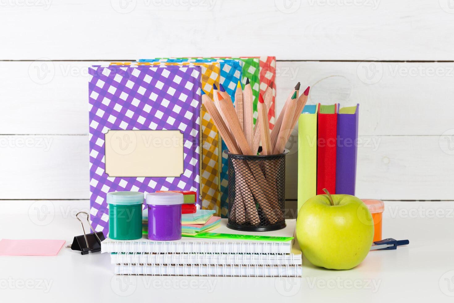 Set of school supplies on white table, front view photo