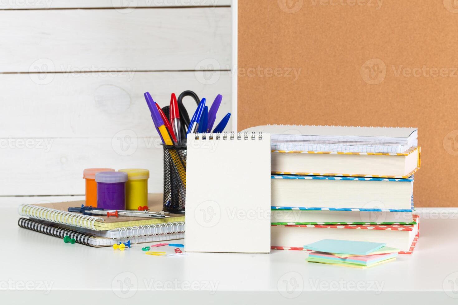 Set of school supplies on white table, front view photo