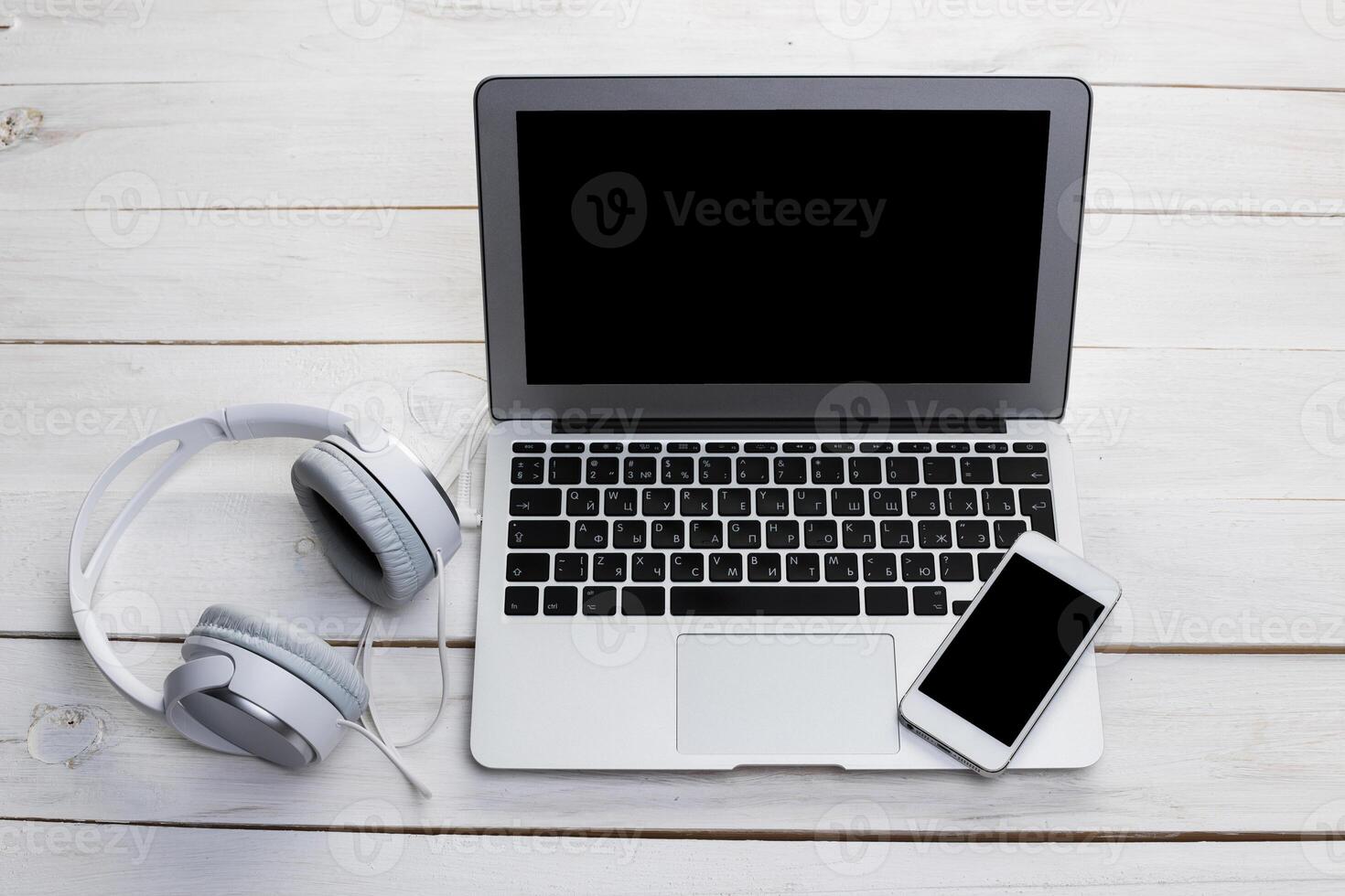 Top view of a wooden table with laptop, smarphone and headphones photo