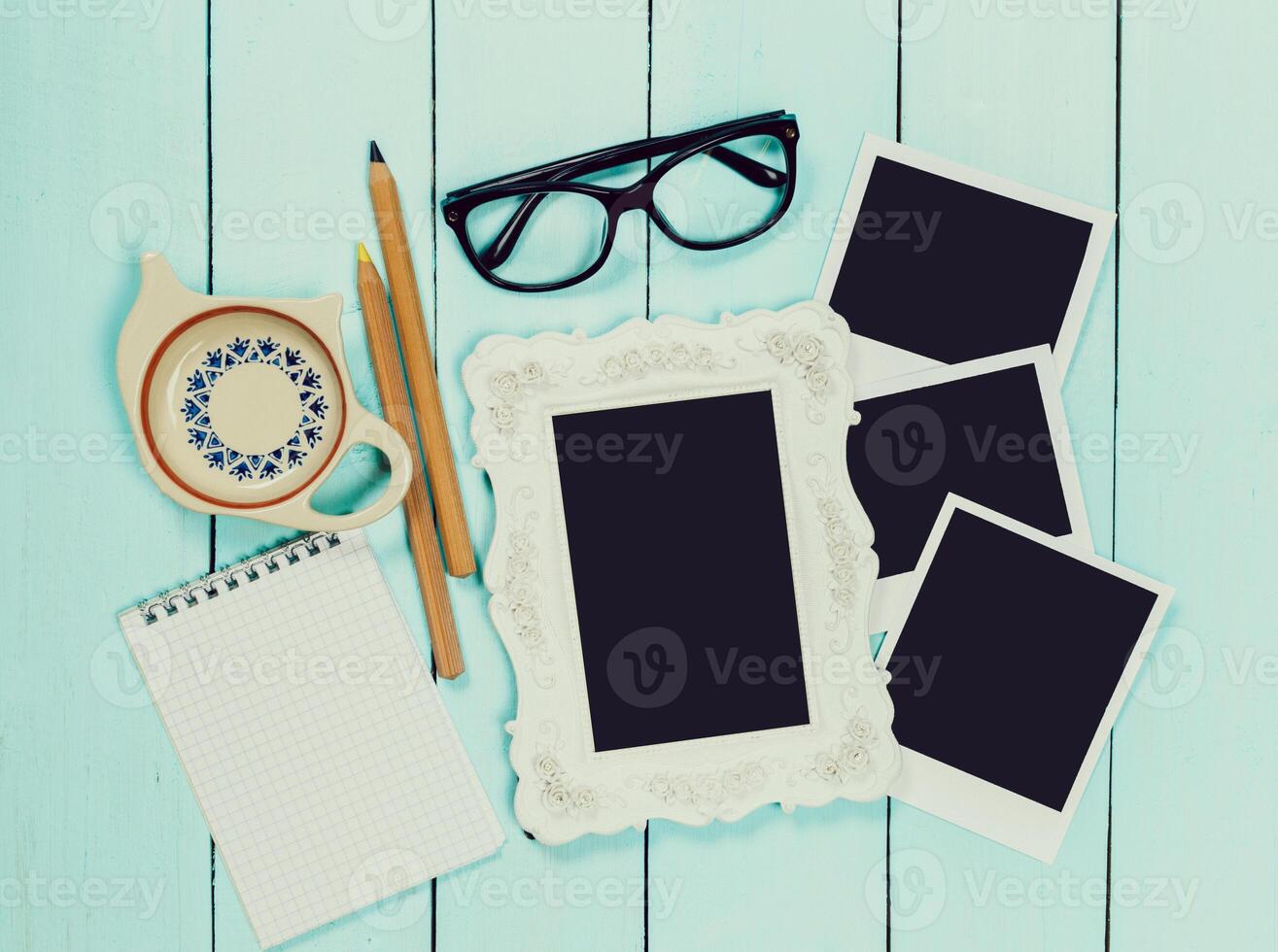 Stationery and personal items arranged on a light wooden table for creative planning and memory keeping photo