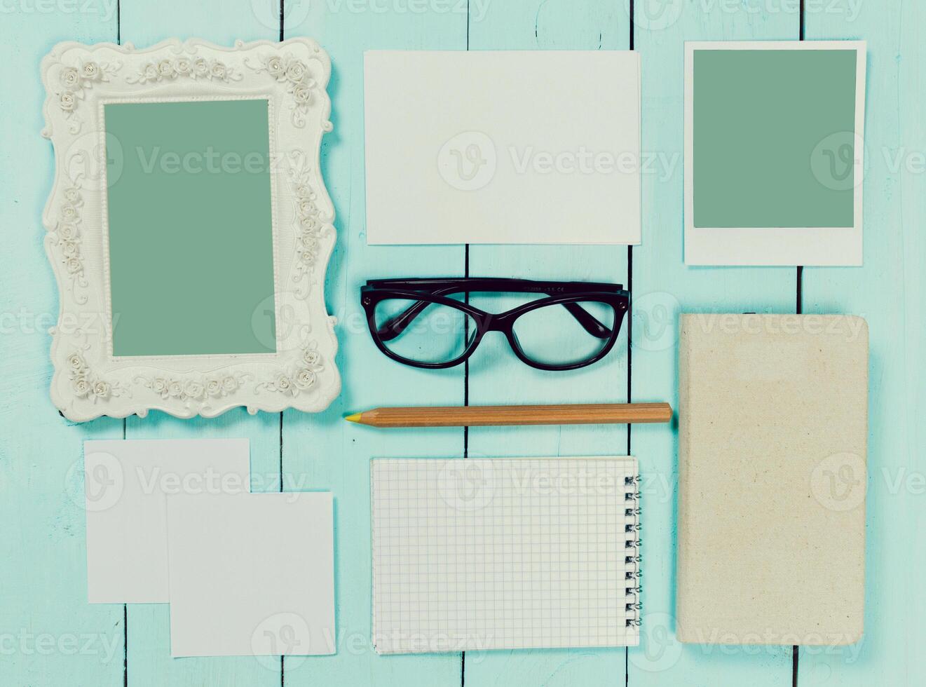 Array of blank stationery and personal items arranged on a light blue wooden table photo