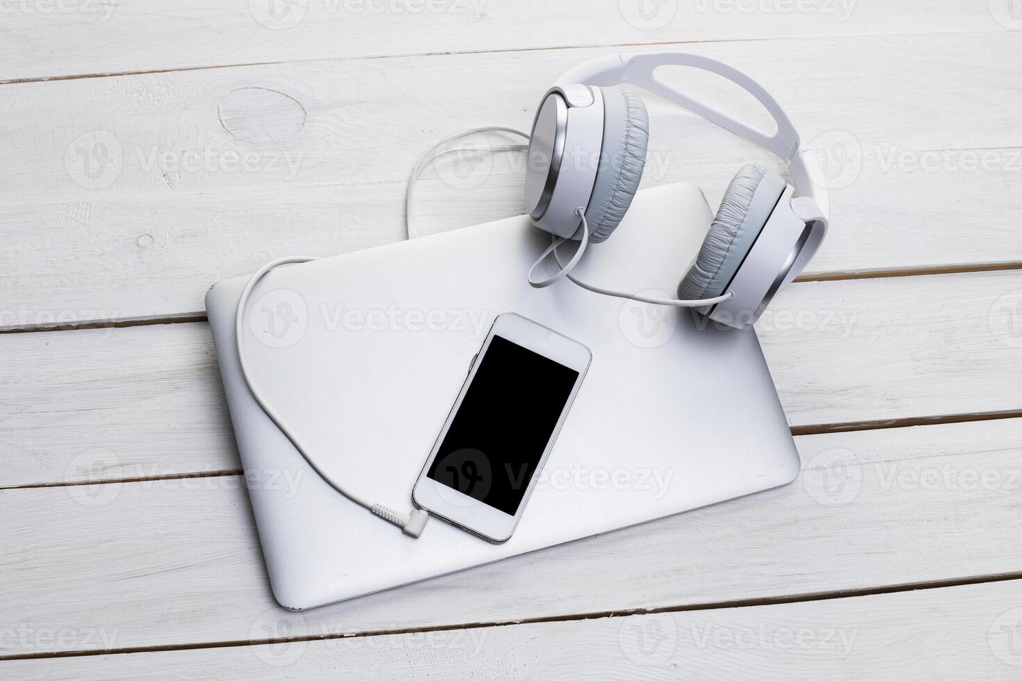 Top view of a wooden table with laptop, smarphone and headphones photo