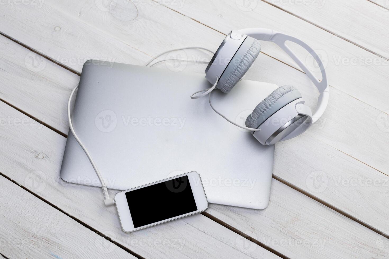 Top view of a wooden table with laptop, smarphone and headphones photo