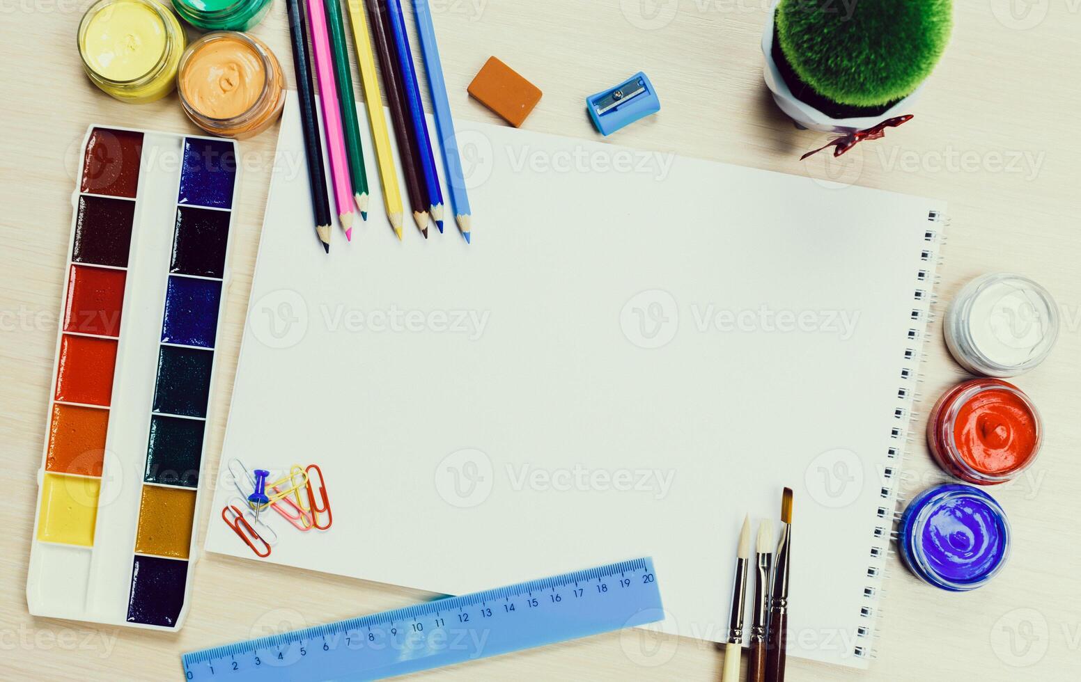 Creative workspace with art supplies, blank paper, and vibrant colors set for artistic projects photo