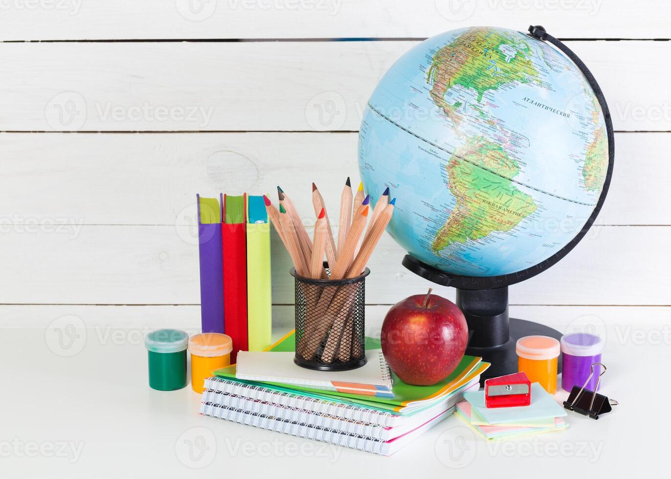 Set of school supplies on white table, front view photo