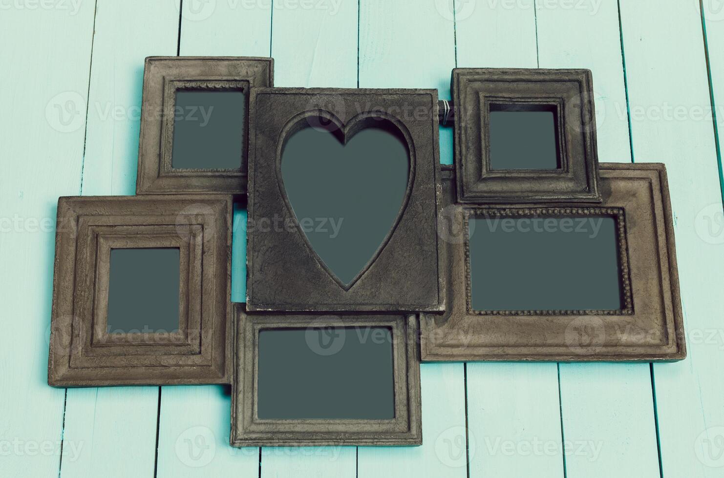 Photo frame with heart shape design displayed against a light blue wooden backdrop