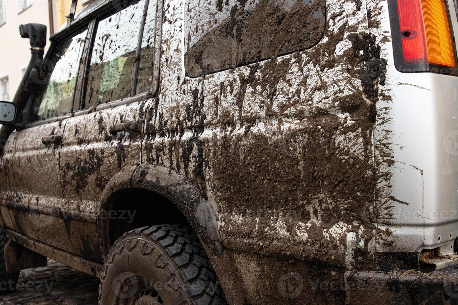 Dirty 4x4 vehicle with mud splatters on body, windows, wheels, tires. Dirty offroad suv car covered in dirt. Rugged terrain adventure, extreme driving, four wheel drive challenges 8 photo
