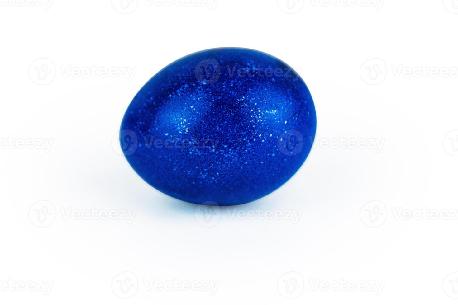 Vibrant ultramarine blue easter egg with glowing shell pattern, isolated on white background. Color contrast, creativity, holiday decoration, symbolism of rebirth. Copy space. Selective focus photo