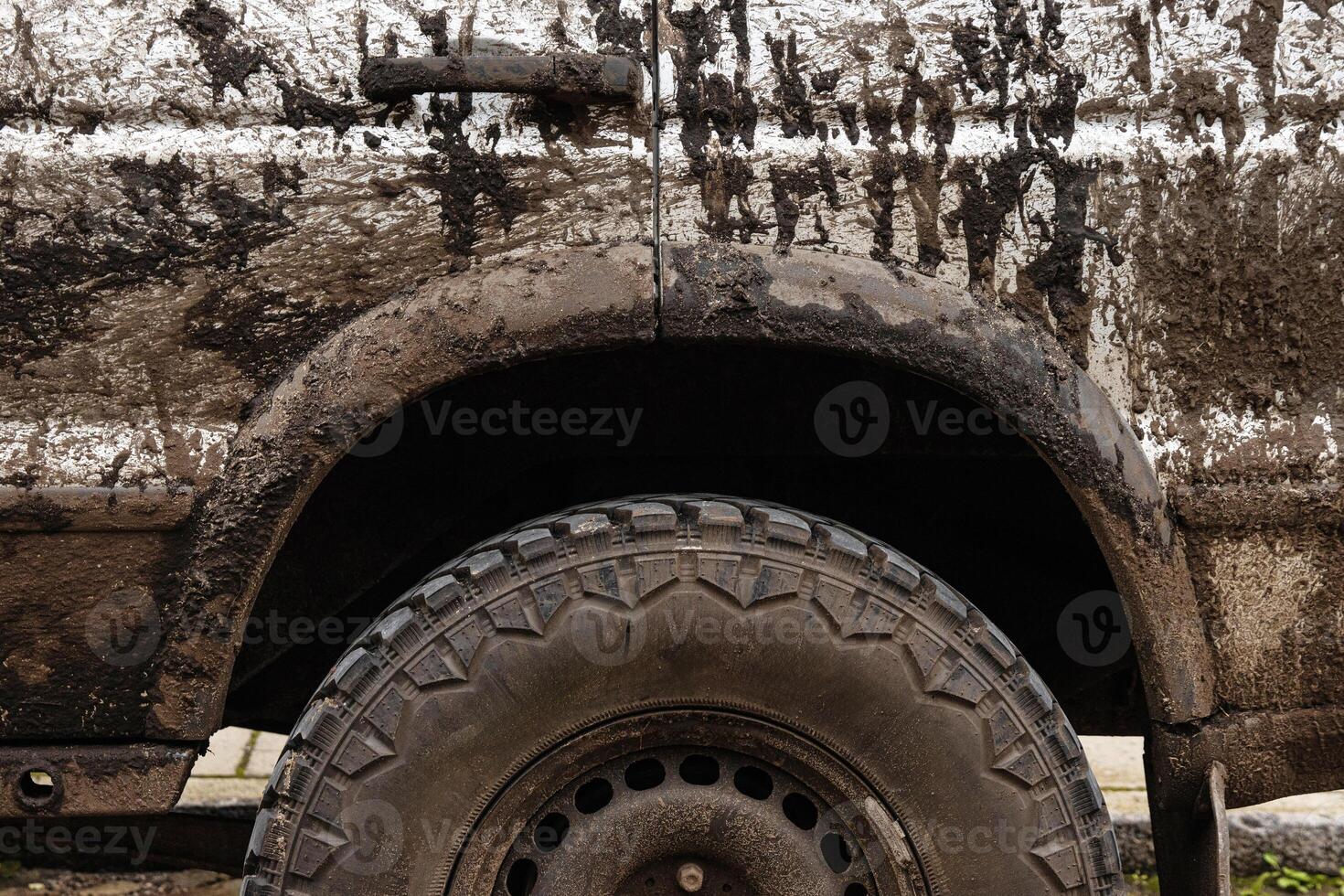 Dirty 4x4 vehicle with mud splatters on the body, wheels and tires. Closeup of a muddy offroad suv car covered in dirt. Importance of car wash, maintenance, and safe driving concept 5 photo