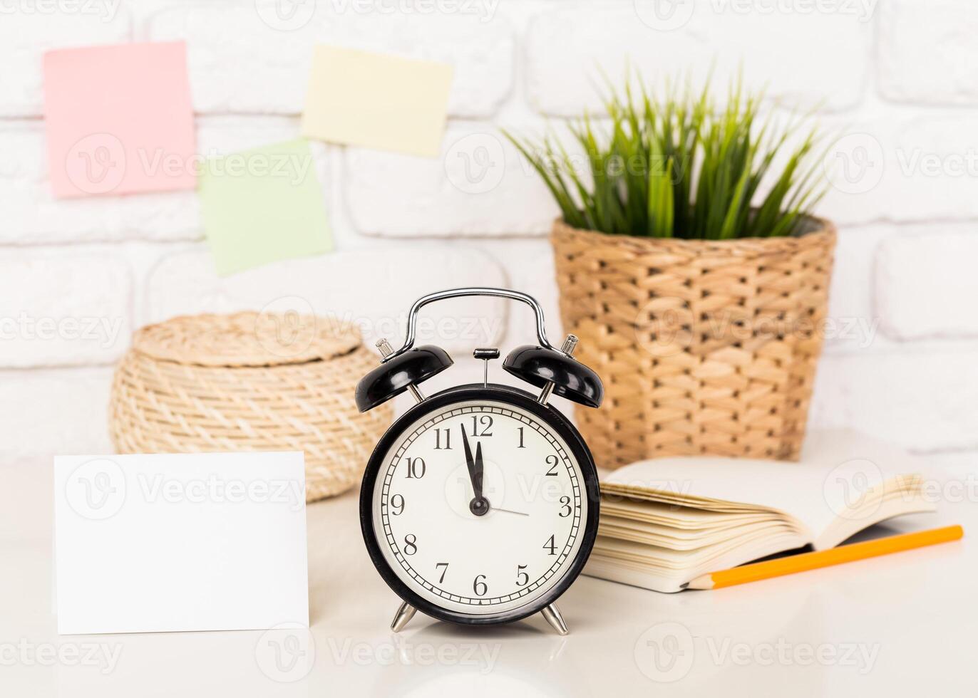 Reminder note and black old-fashioned alarm clock photo
