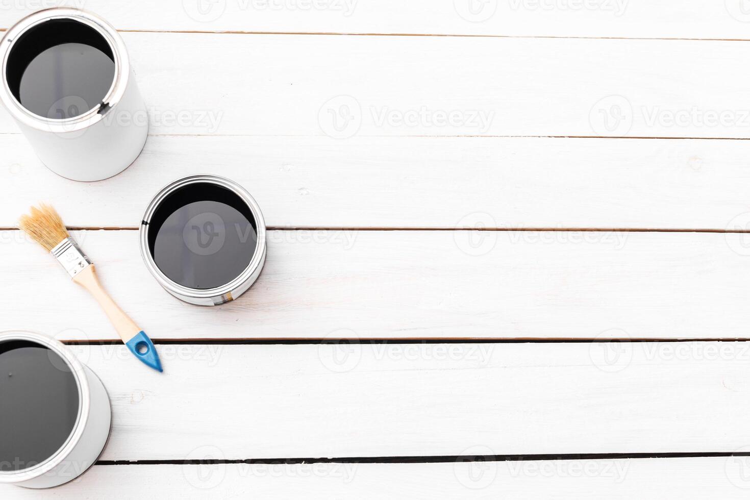Top view of metal cans with paint on white wooden background photo