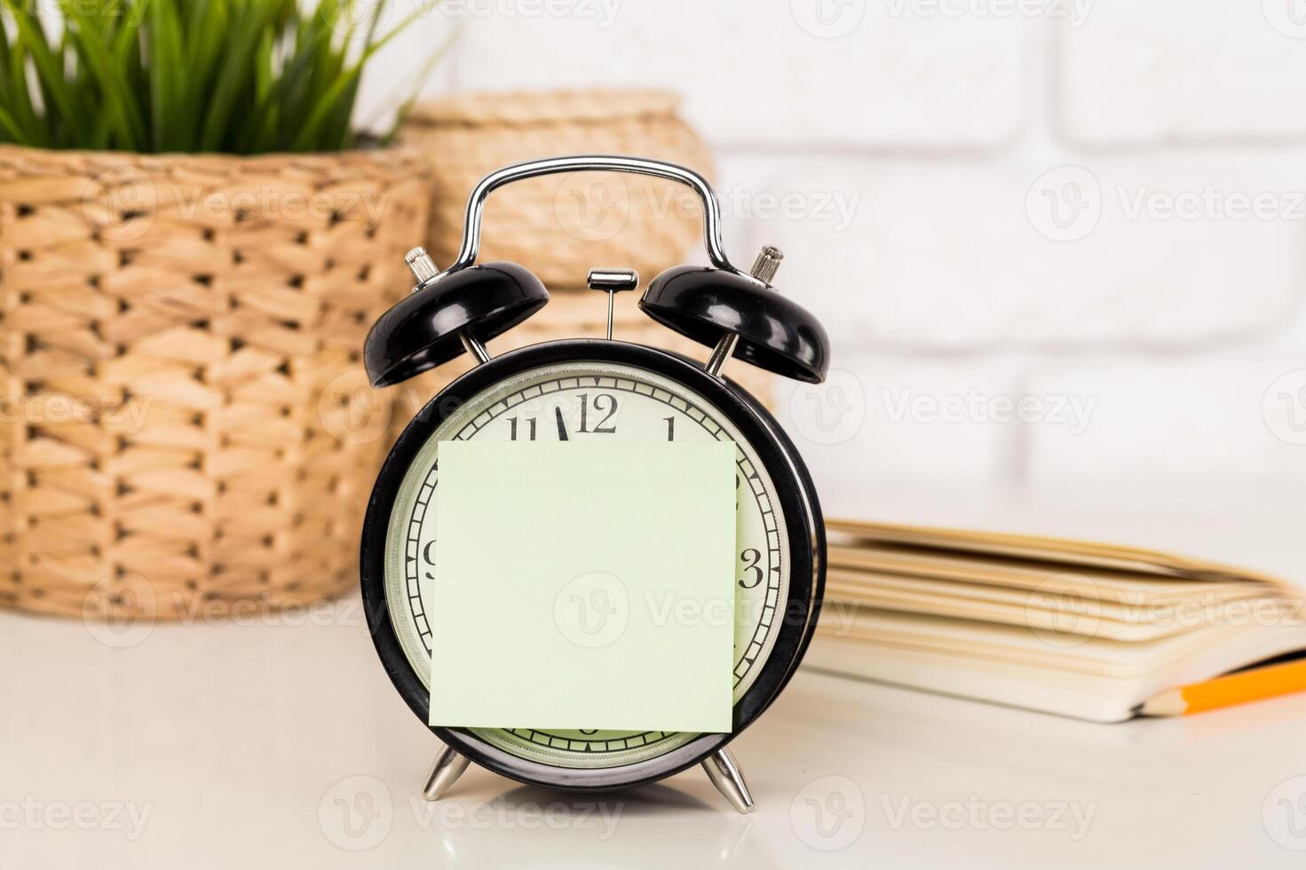 Reminder note and black old-fashioned alarm clock photo