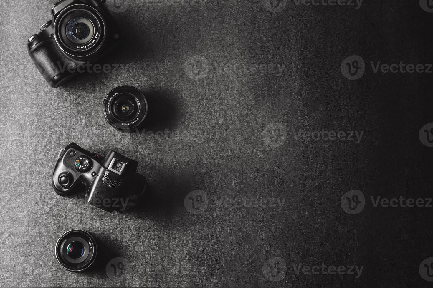 Professional cameras with different lenses on a black table photo