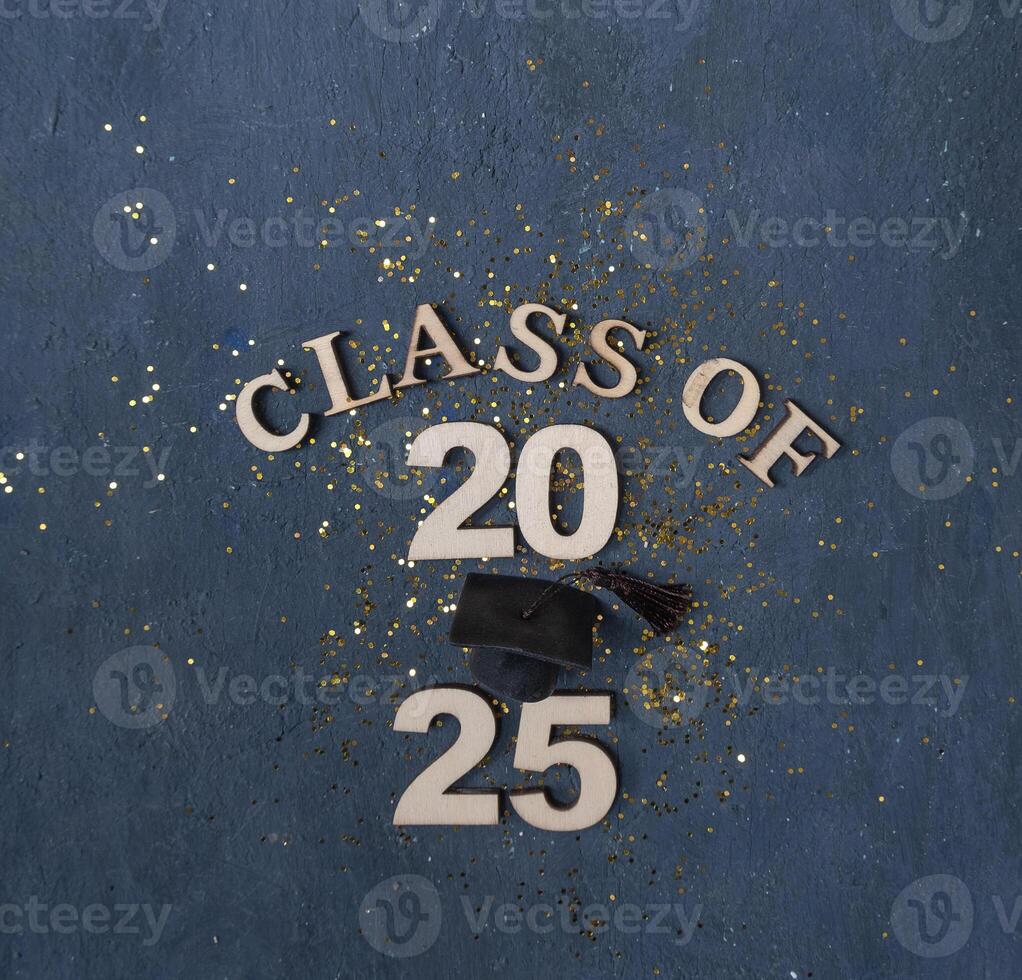 Graduation cap on wooden number 2025 on dark background. Class of 2025 photo