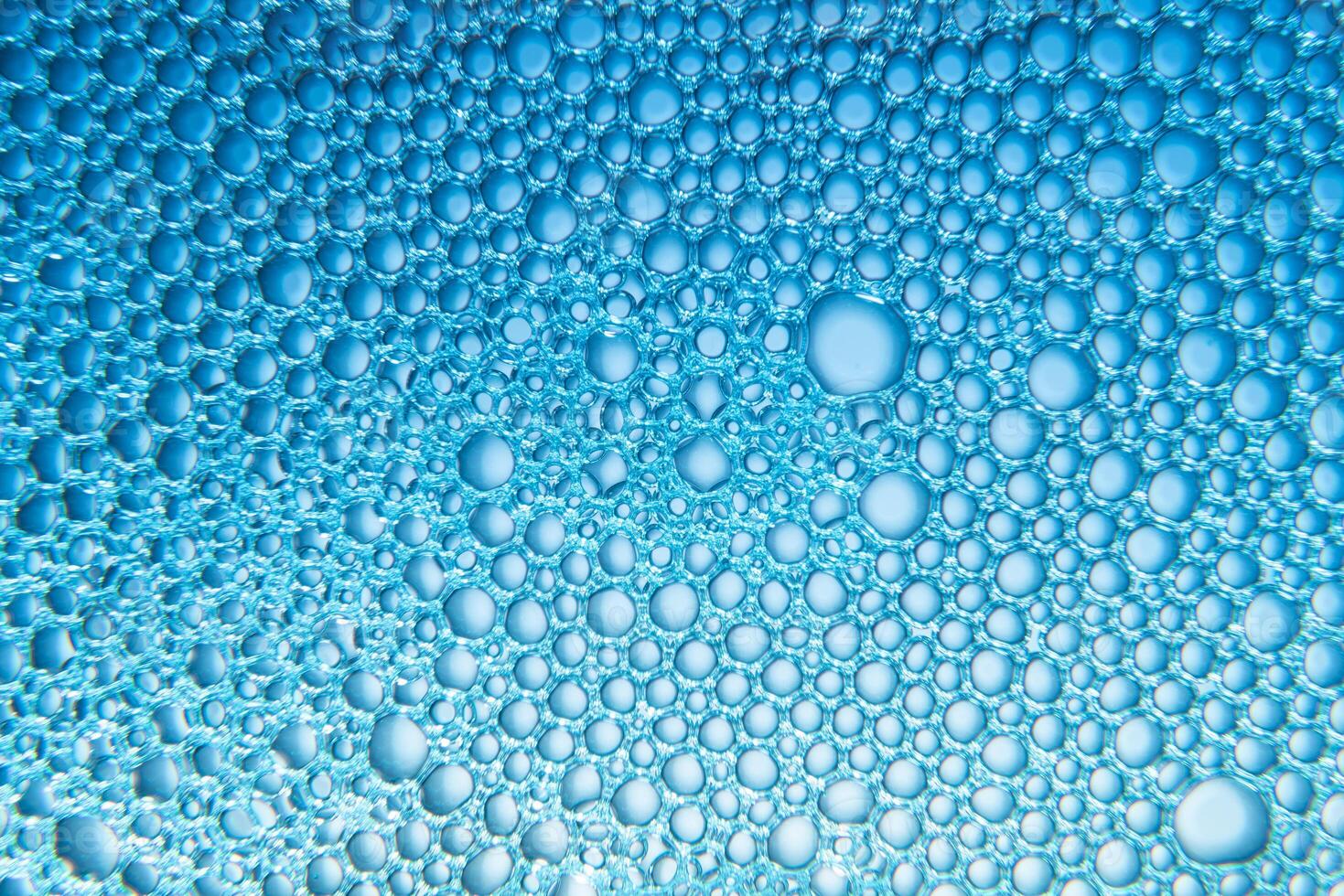 Texture of soap bubbles and water with blue light photo