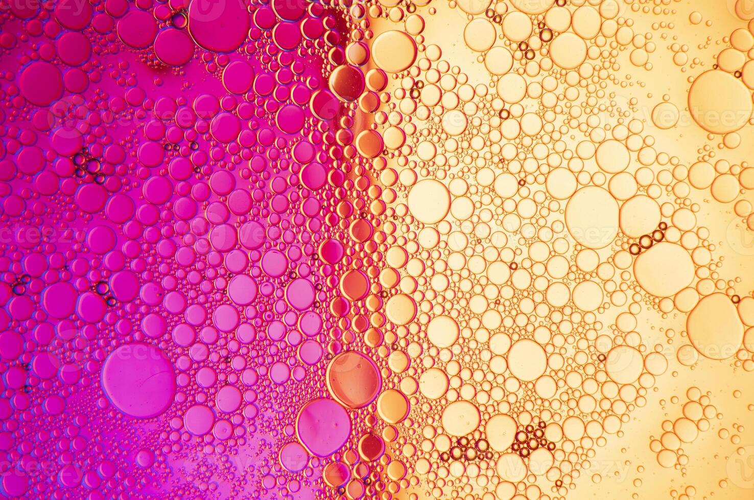 Abstract composition with water and oil drops against magenta and yellow background photo
