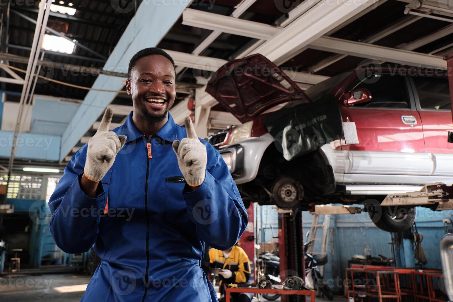 Portrait of confident Black male mechanic inspector, cheerful works and pose with smile in fix car garage, professional engineer maintenance jobs in automotive and transportation industry business. photo