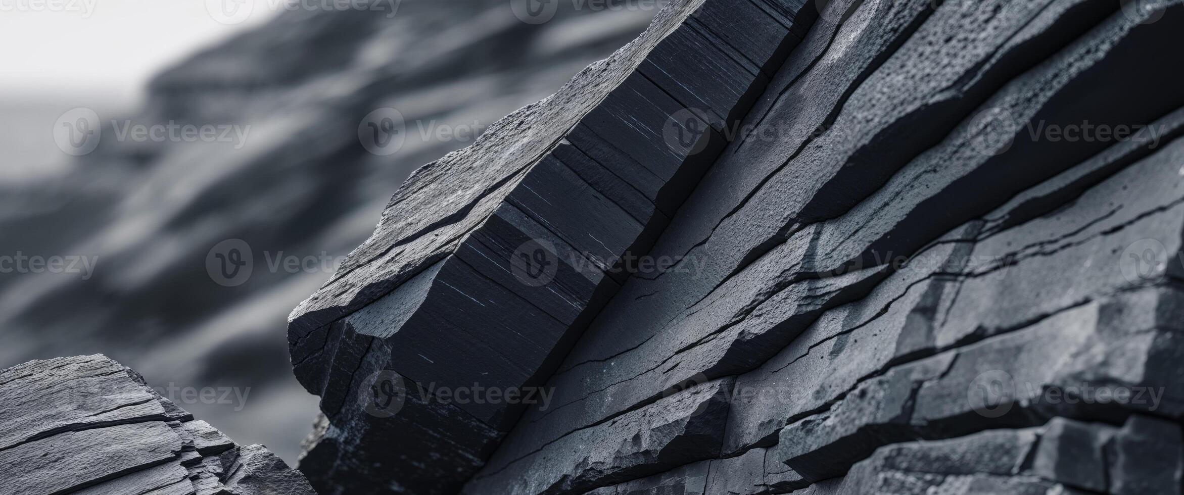 Dark grey and black rock face showing texture and strata photo