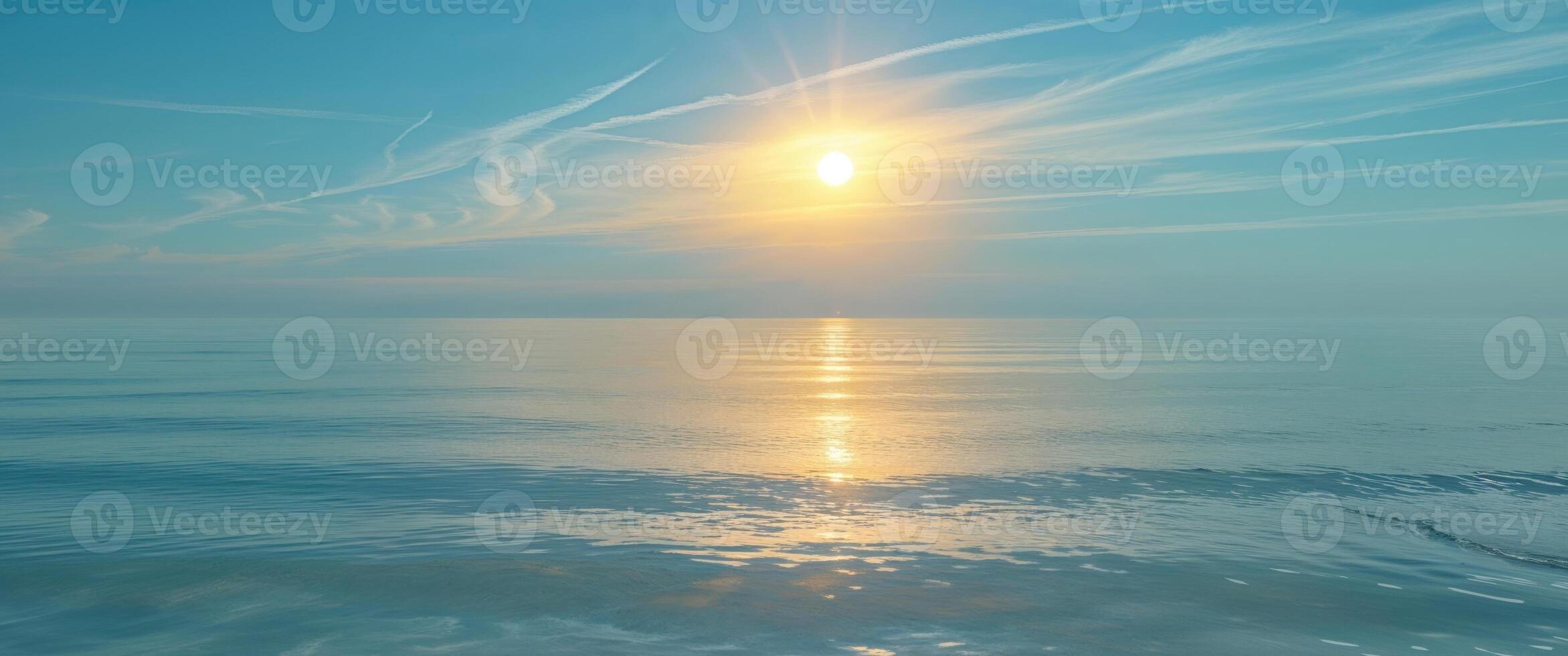 A beautiful ocean with a golden sun reflecting on the water photo