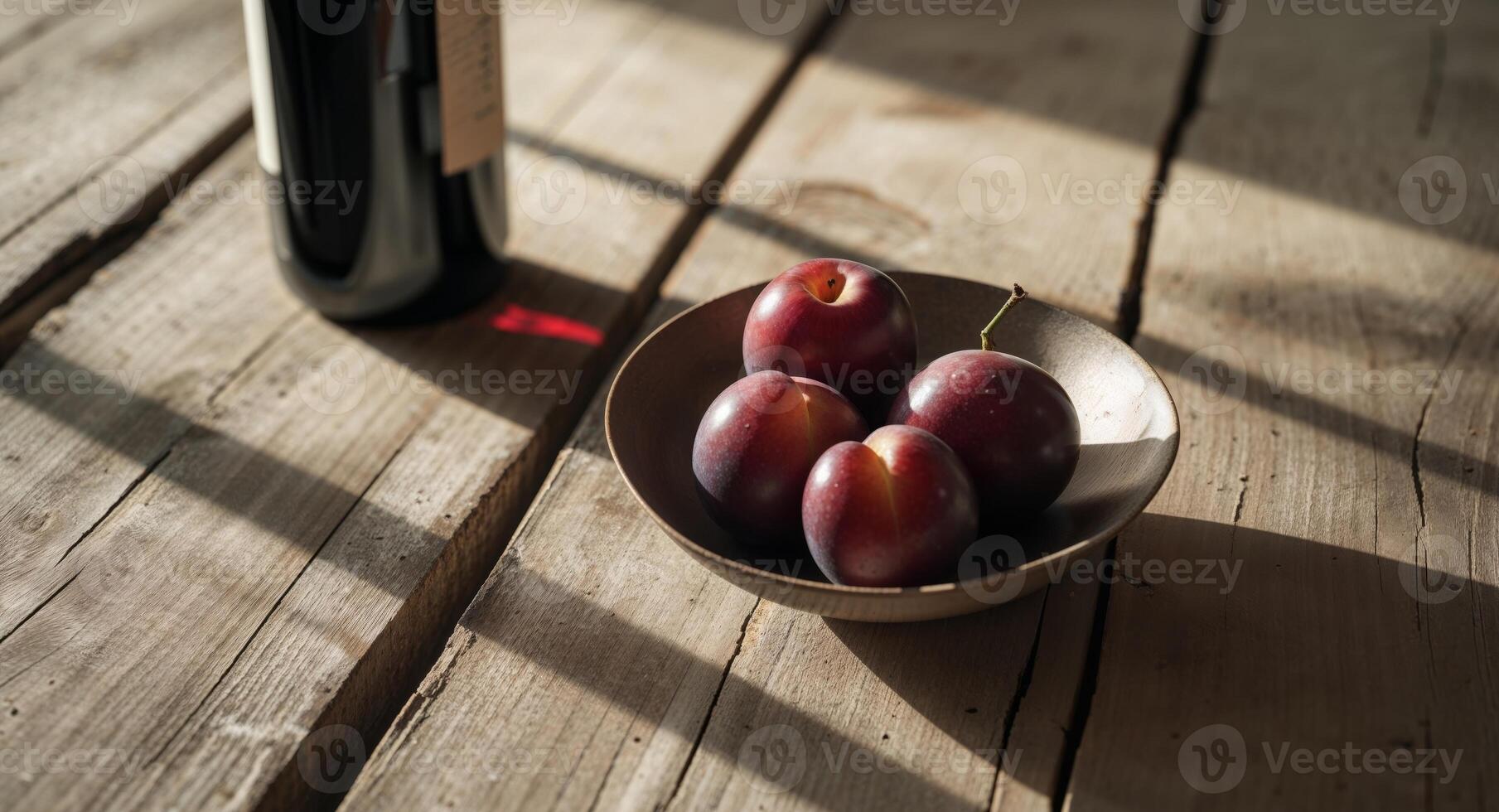 Rustic wooden table with wine and plums in soft light photo
