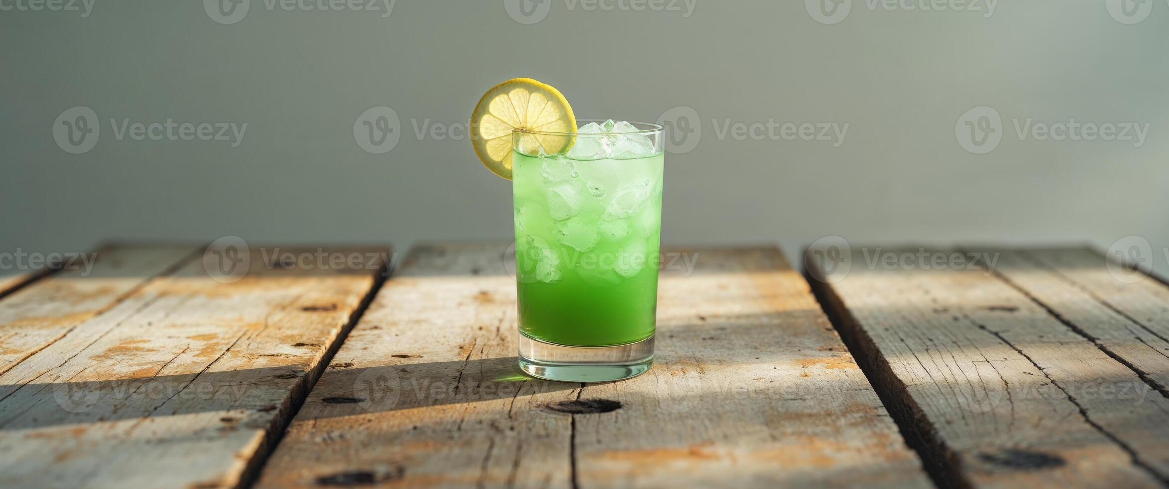 Refreshing green drink with lemon and ice served on a rustic table photo