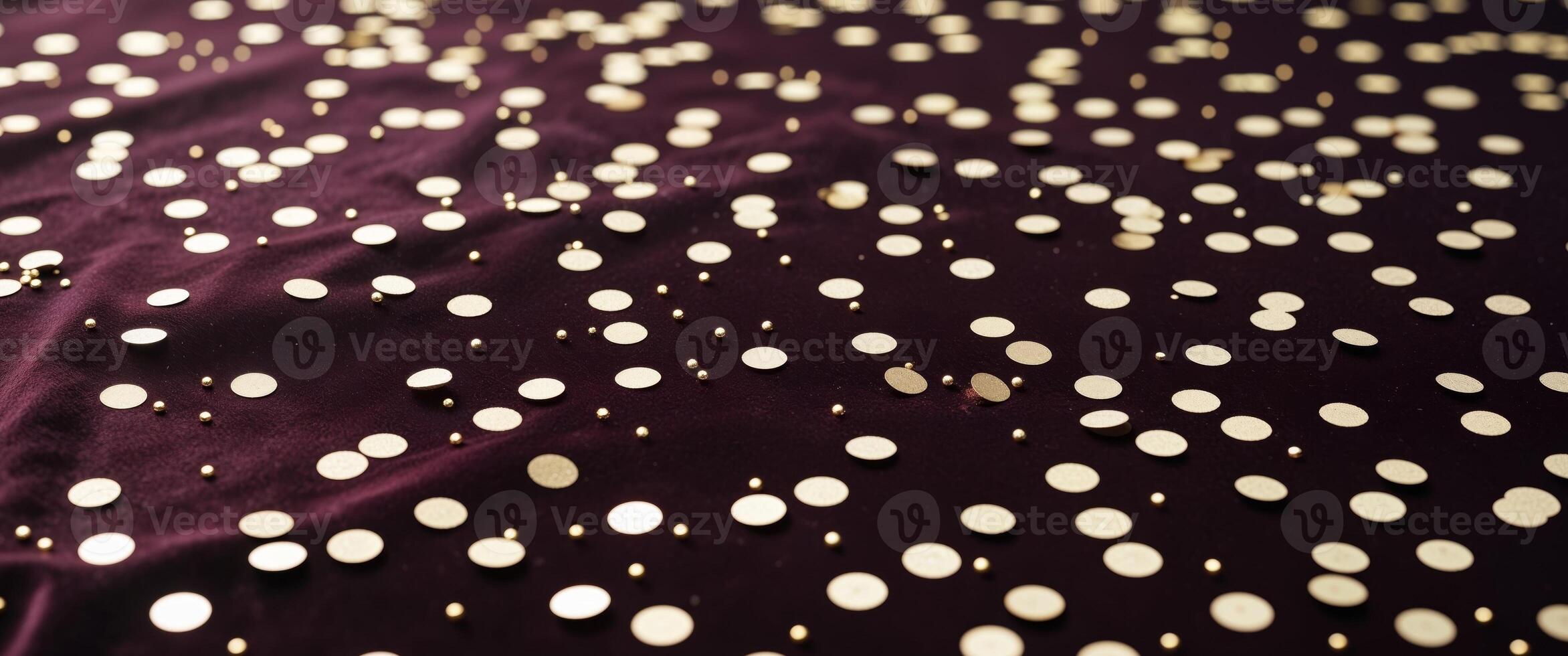 Shimmering golden confetti scattered on dark velvet background. photo