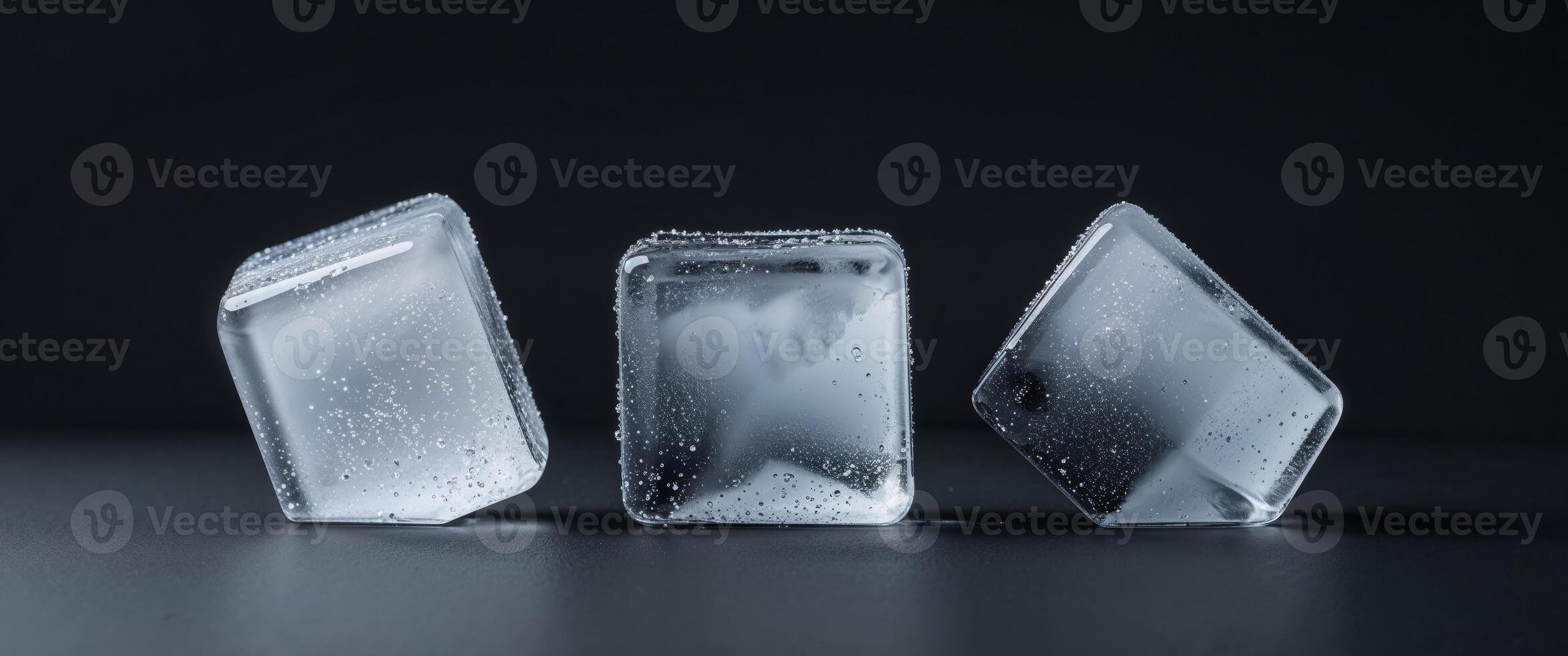 Three ice cubes on black background cold refreshing water. photo