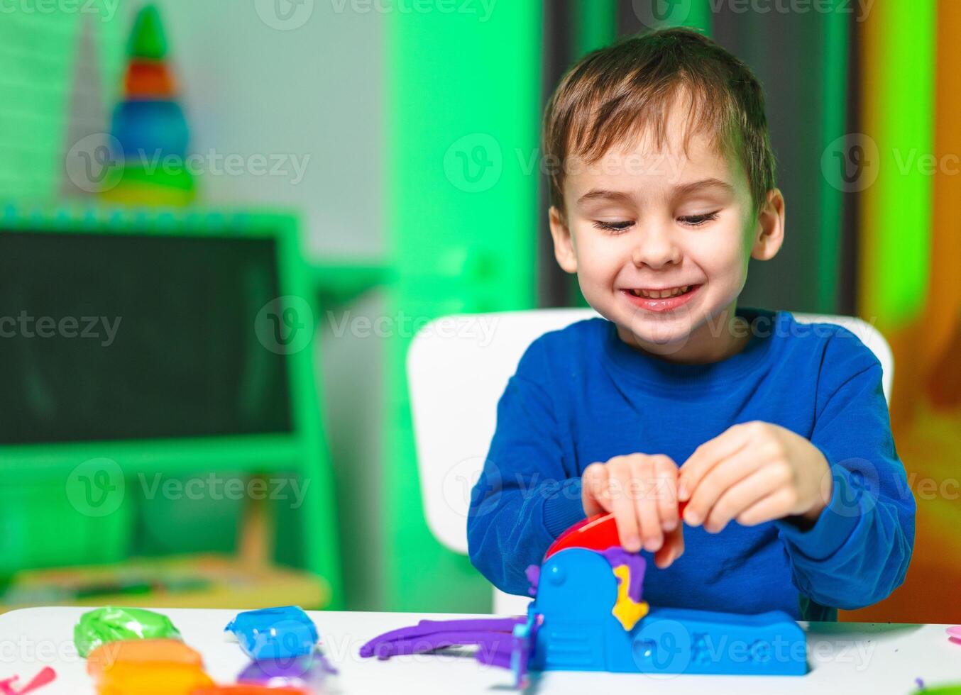 Child plays with bright toys. A young boy enjoys playing with a bright toy set, showing joy and concentration during a creative activity at home. photo