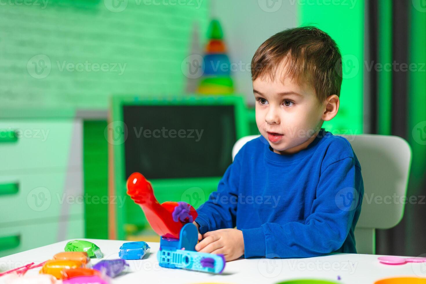 Boy enjoys creative playtime. A young boy plays enthusiastically with colorful toys, expressing joy and curiosity in an inviting space. photo