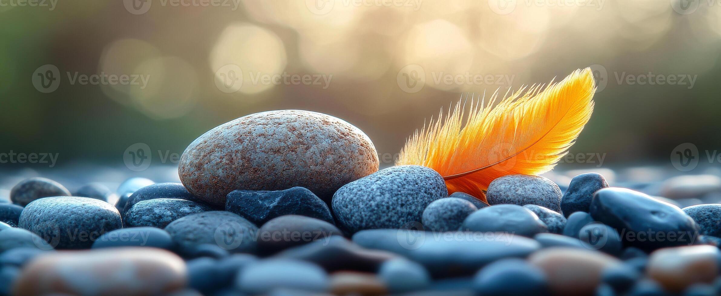 Feather on smooth stones. A vibrant orange feather lies atop smooth stones, capturing the beauty of nature in soft light during sunset. photo