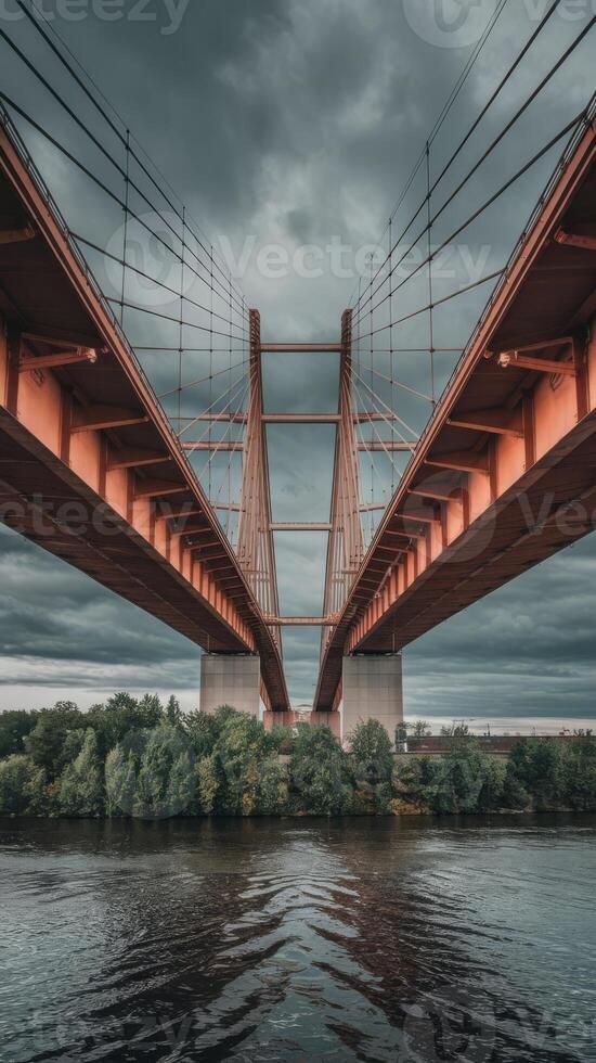 A bridge spanning over a river with dark clouds photo