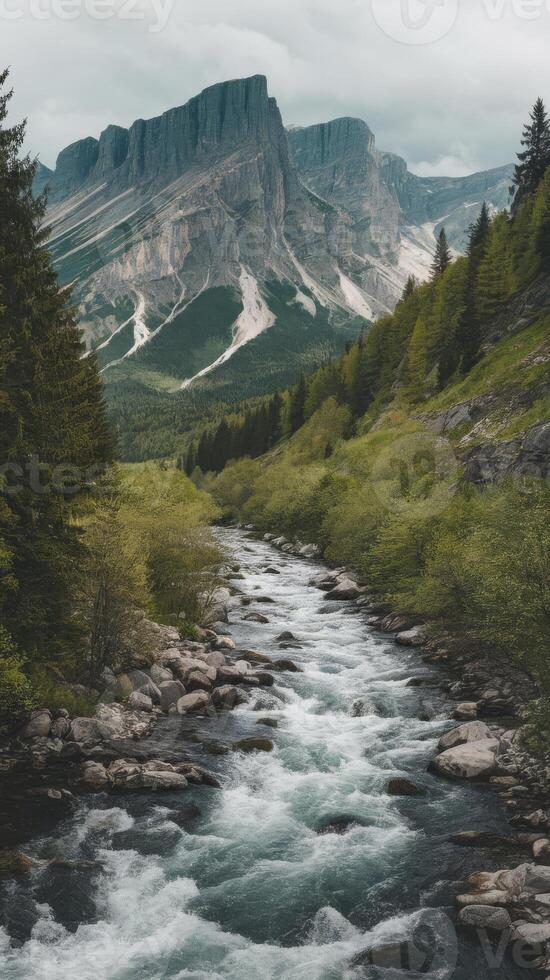 A river flowing through a mountain valley with trees and mountains photo