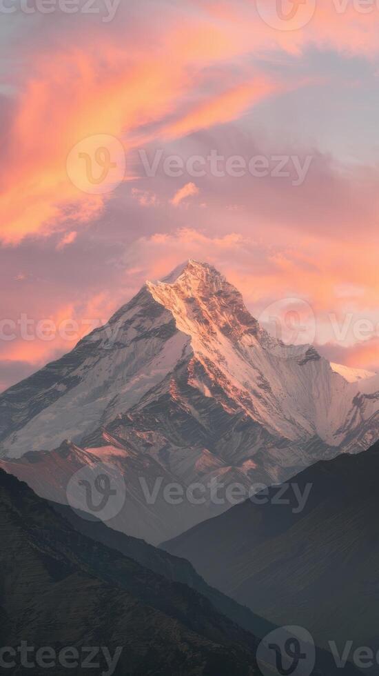 A mountain with a pink sky and snow covered peaks photo