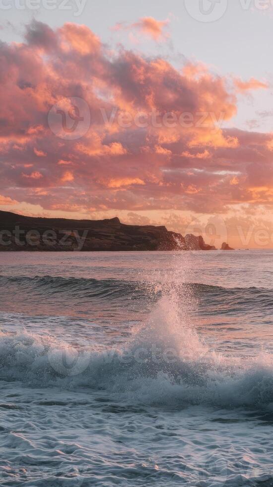 A sunset over the ocean with waves crashing into the shore photo