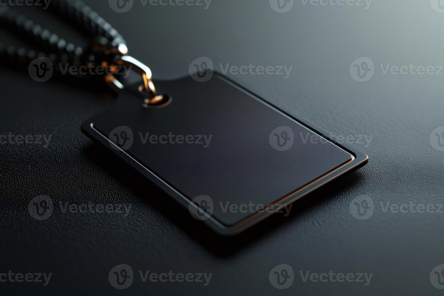 Blank black rectangular label with chain on dark background is hanging photo