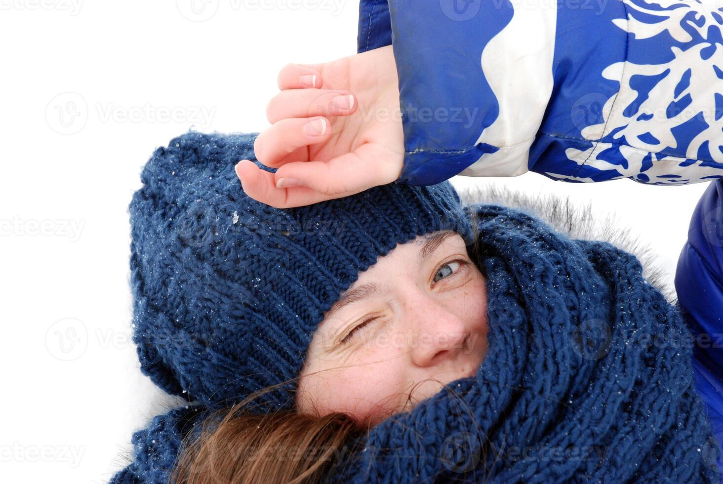 Winter joyful woman winking in cozy blue hat and scarf photo
