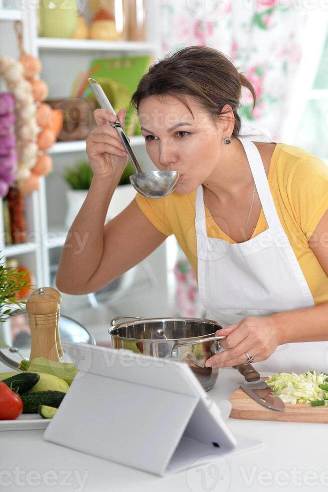 Portrait of a beautiful young woman cooking in the kitchen photo