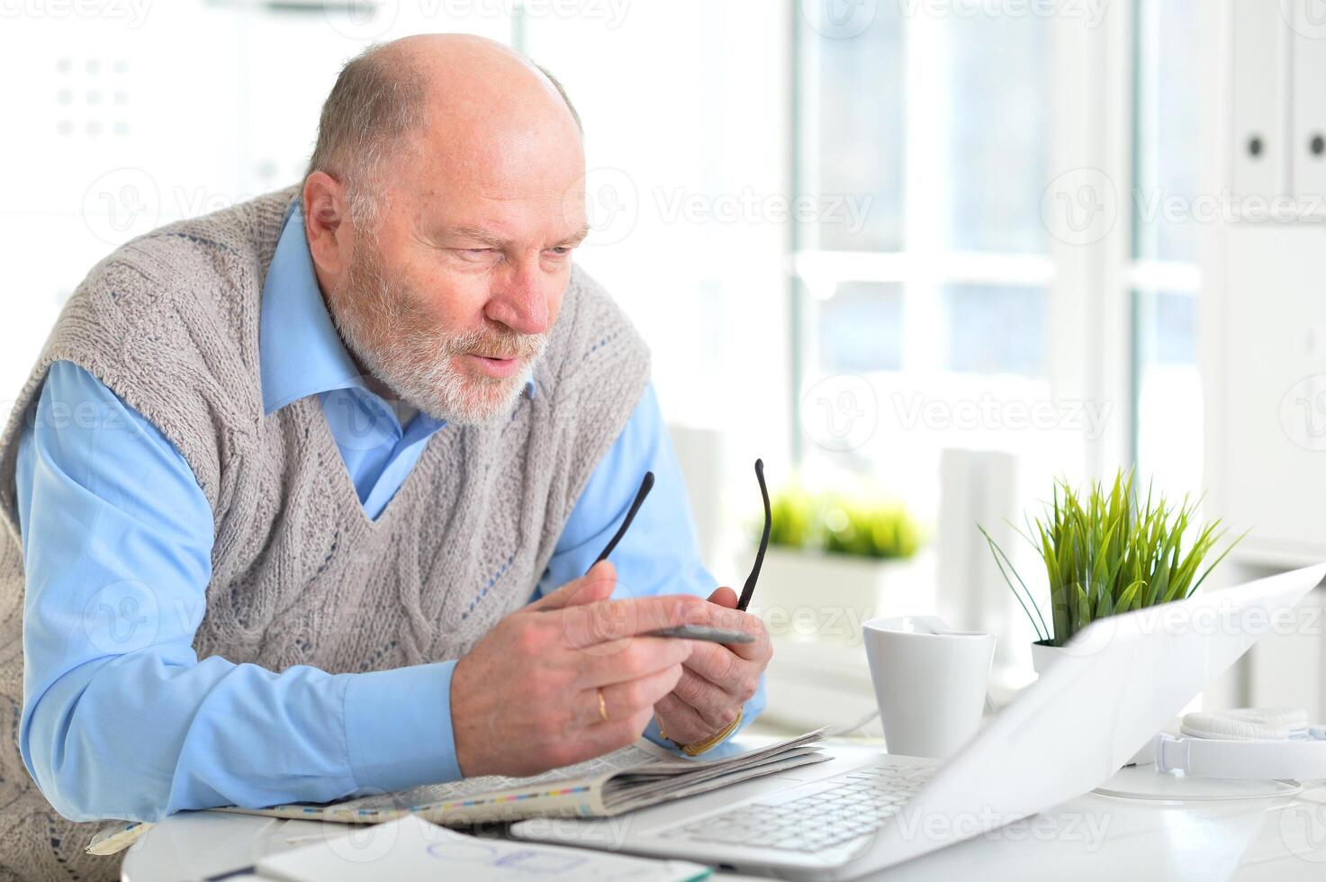 Portrait of an elderly man using a laptop in an office photo