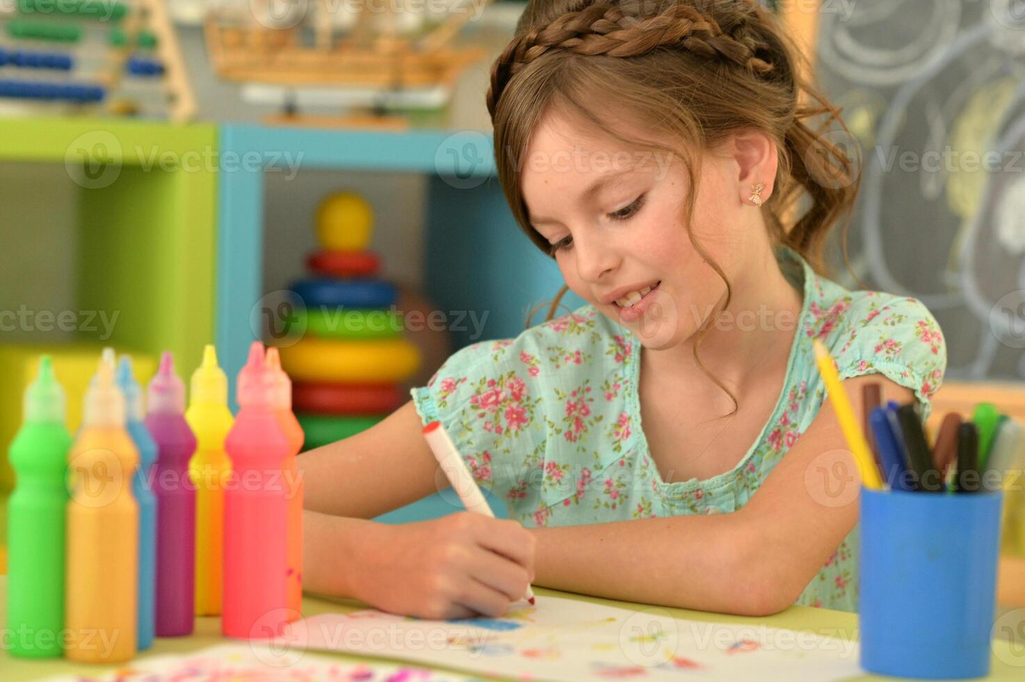 Portrait of cute girl drawing picture at home photo