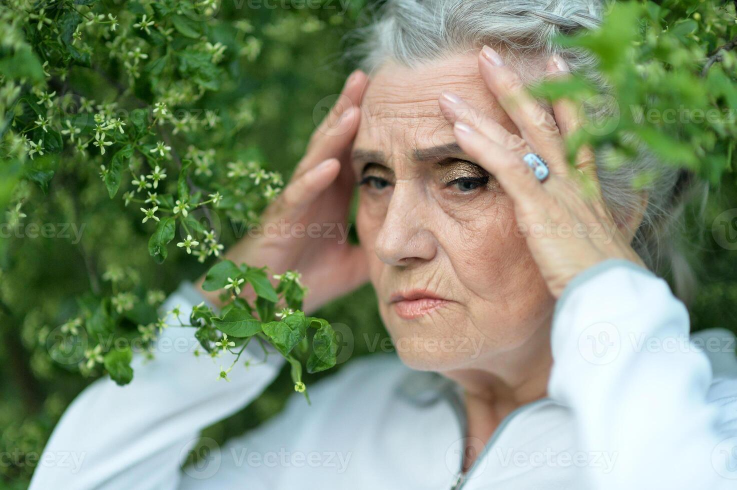 Portrait of senior sad woman in park photo