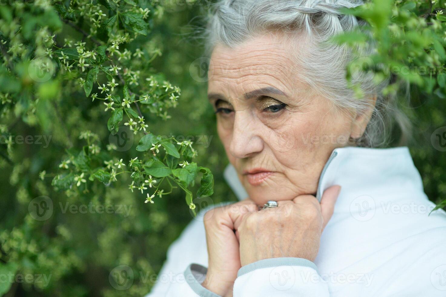 Portrait of senior sad woman in park photo