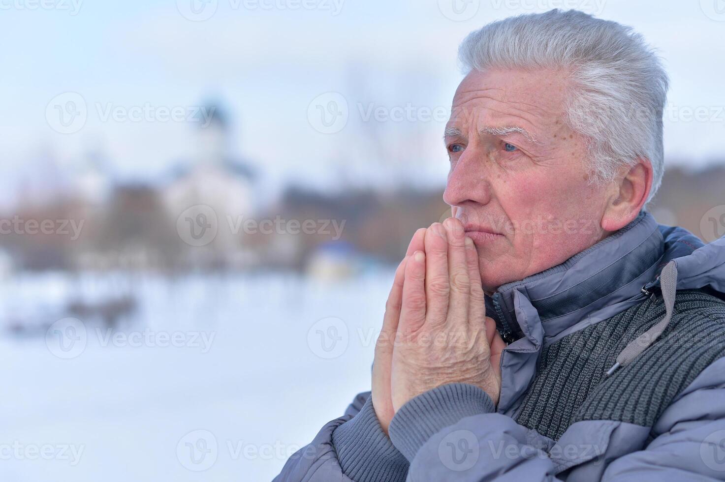 Close up portrait of sad senior man posing outdoors photo