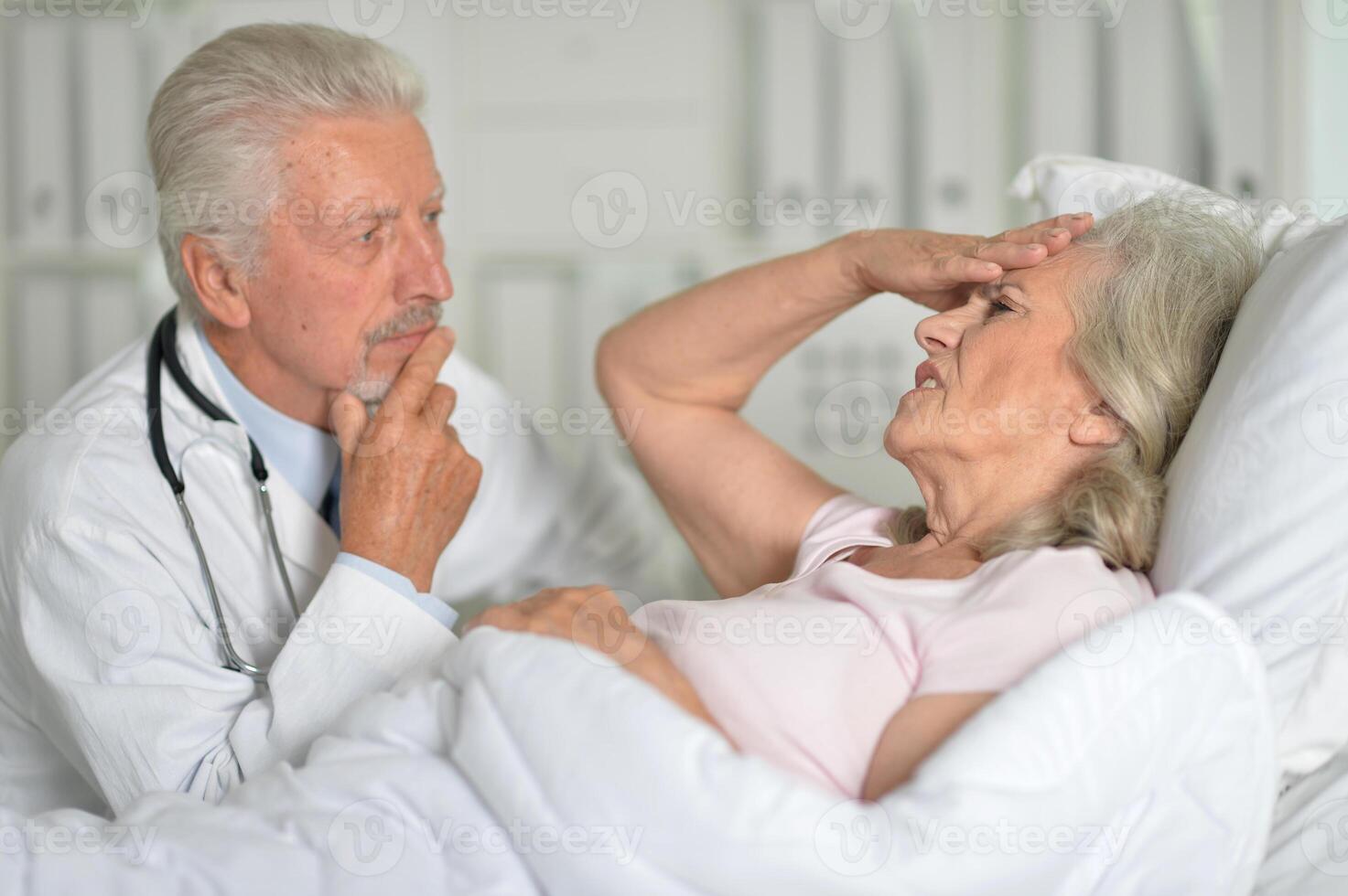 An elderly woman in the hospital with a doctor photo
